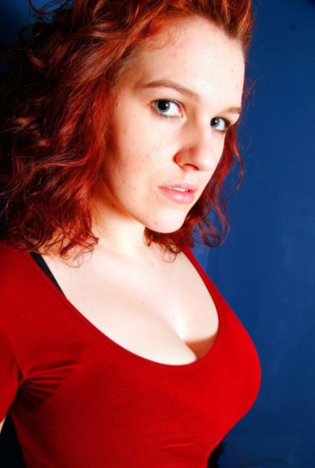 Her large natural tits are free of a brassiere as Eva, a choosy redhead, sets them aside.