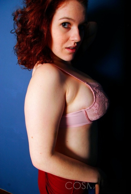 Eva, a bulbous redhead, releases her large natural tits from the brace.