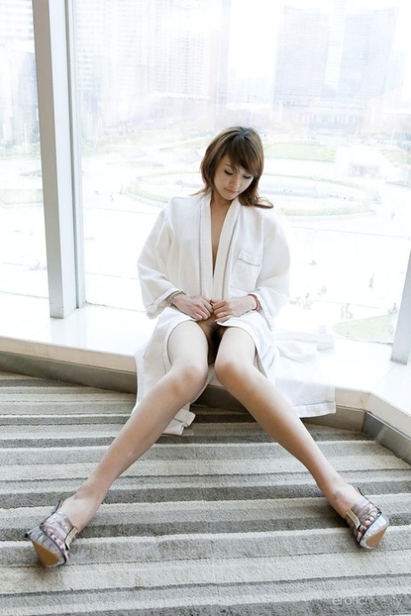 Young Asian girl Lavinia Chan turns off the robe to pose naked on the window sill.