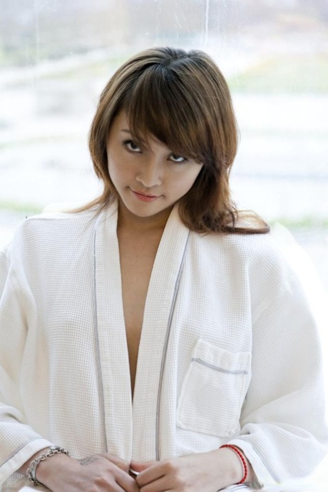 Young Asian girl Lavinia Chan turns off the robe to pose naked on the window sill.