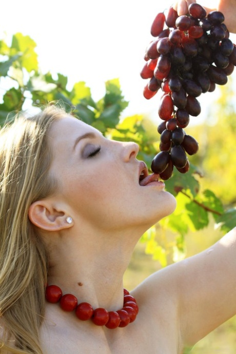 Tinaa, the blonde model, performs impressive nude poses while picking grapes from the garden.