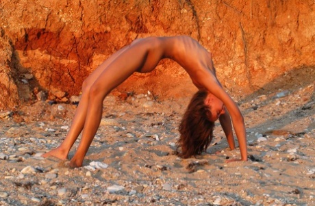 On a beach, Vika V showcases her flexibility while being naked.