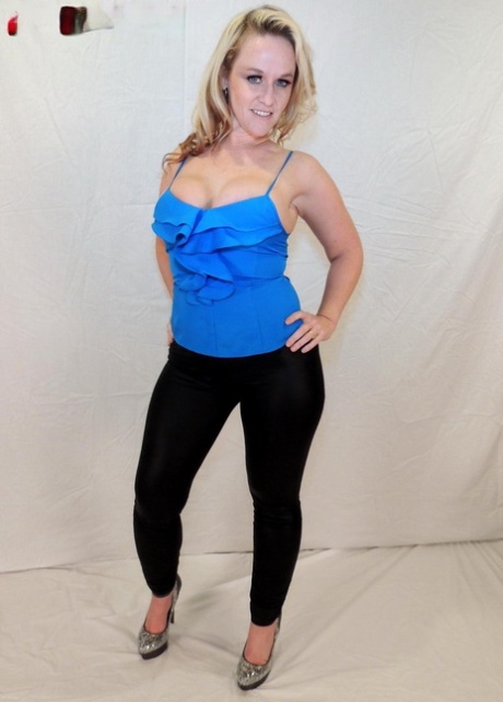The ample bust of Dee Siren, a middle-aged blonde, is visible in her tight pants.