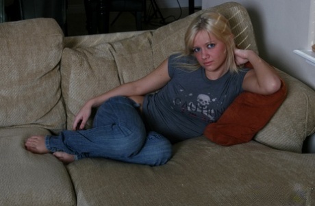 Young blond Danielle Lynn holds her perky tits in hand before removing her jeans.