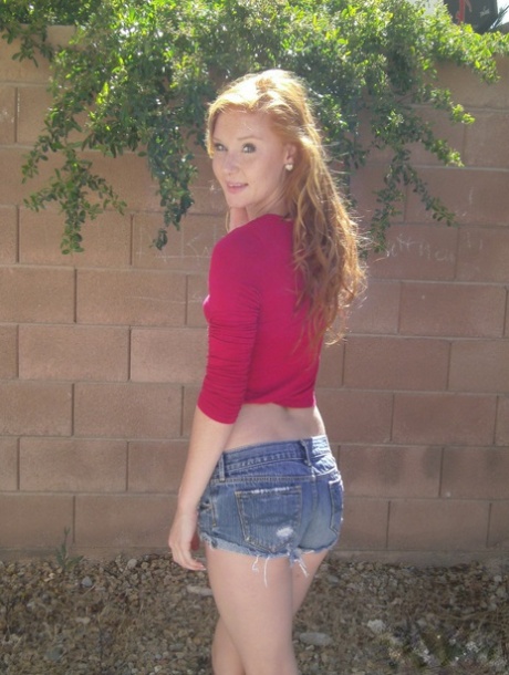 A hot, red-haired beauty called Alex Tanner flashes her tiny tits and drops off her shorts while out in the sun.