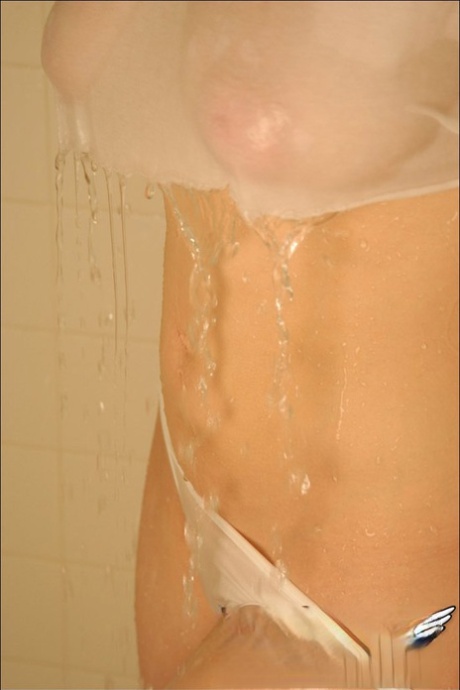 Cute teen girl takes a shower with her see thru clothes on her busty body