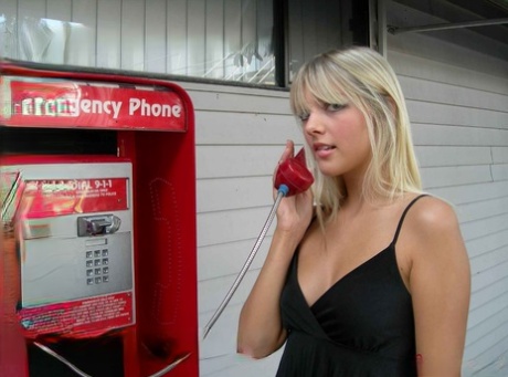 Blonde amateur Jana Jordan flashes her panties at a public phone