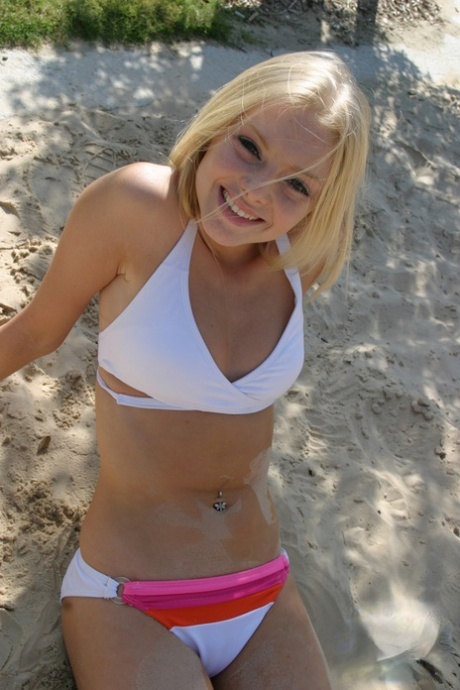 Petite teen Skye Model wearing sexy white bikini and flip flops on the beach