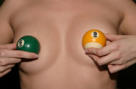 A charming young woman with blonde hair, Jana Jordan, is seen laughing aloud in her lingerie while shooting pool.