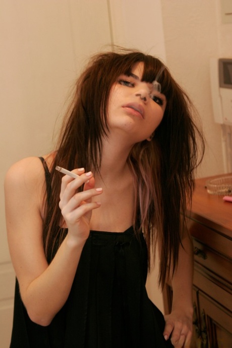 Миниатюрная 18-летняя Кайра курит сигарету, раздеваясь в своей спальне