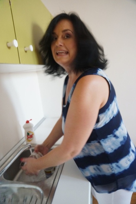 Ria Black, an older housewife, removes her hands and pussy after washing dishes.