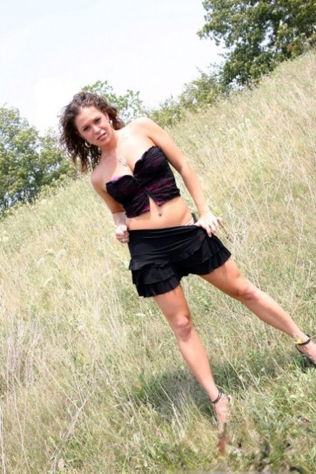 Teen amateur shows some cleavage during a SFW shoot out in a field