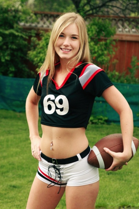 Stunning blonde Jewel donned athletic clothing to pose without any clothing while holding a football.