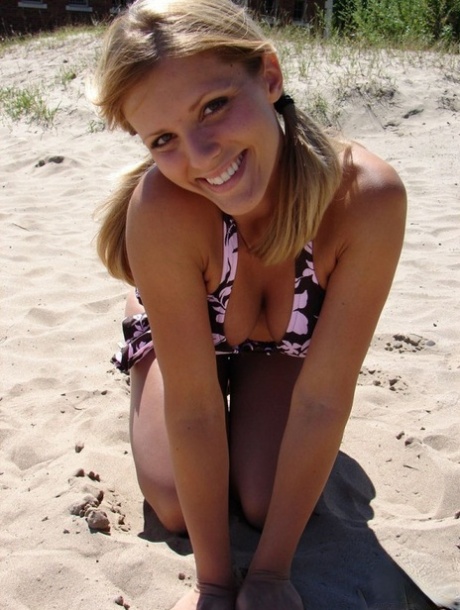 Sexy Karen models a bikini on the beach in an area of sand.