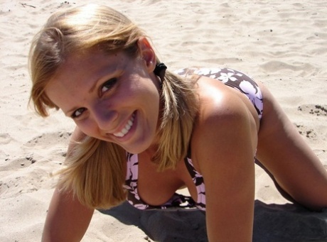 Blonde teen Karen models a bikini while on a patch of sand