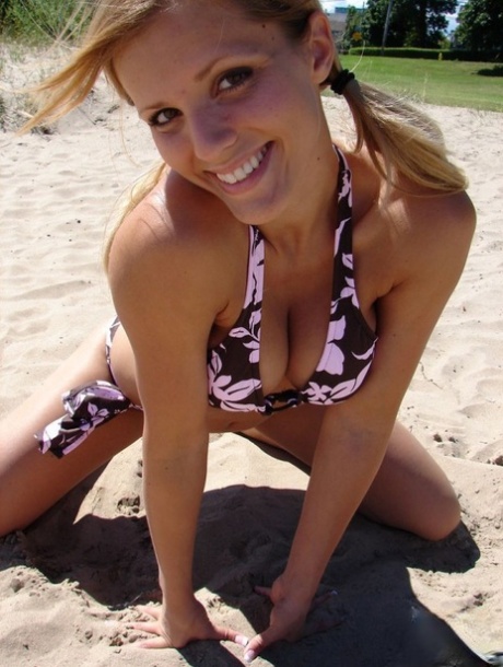 On a patch of sand, Karen is seen wearing her tee and modeling in a bikini.