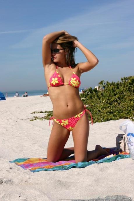 Teen solo girl Karen relaxes at the beach in a bikini and sunglasses