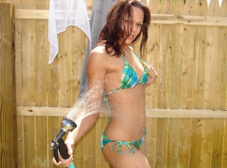 Young Amateur Wets Herself With A Garden Hose While Wearing A Bikini