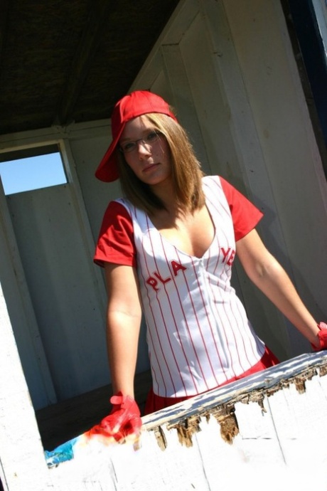 Sporty teen shows her bra and cleavage in a micro skirt baseball uniform