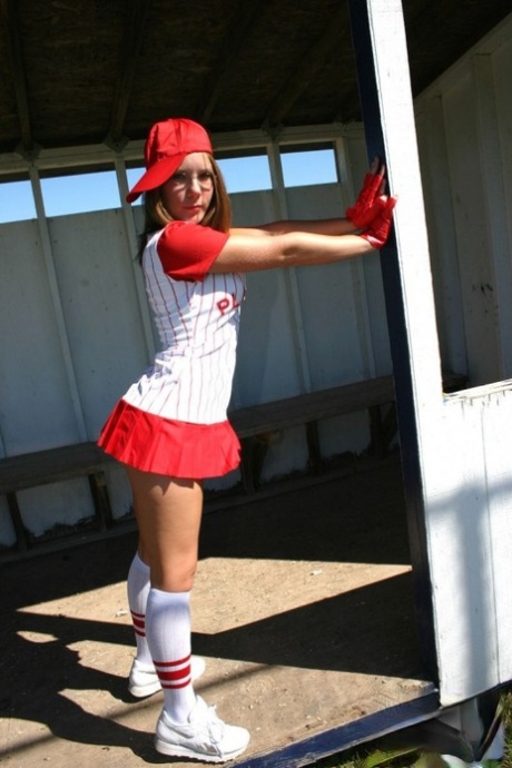 Sporty teen shows her bra and cleavage in a micro skirt baseball uniform