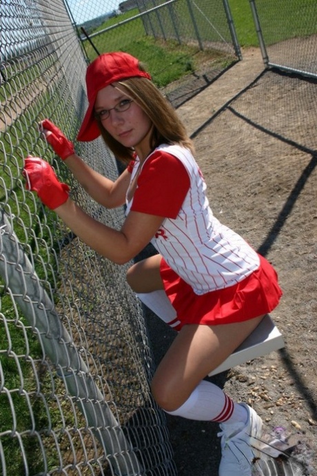 Sporty teen shows her bra and cleavage in a micro skirt baseball uniform