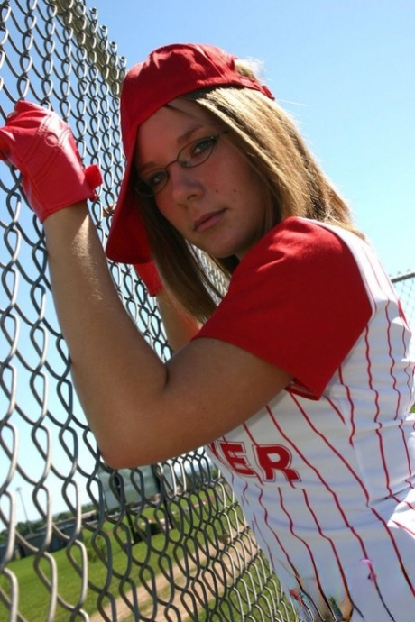 Sporty teen shows her bra and cleavage in a micro skirt baseball uniform