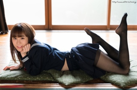 Japanese student bares her slim figure on a cushion after school, as she emerges from her school attire.