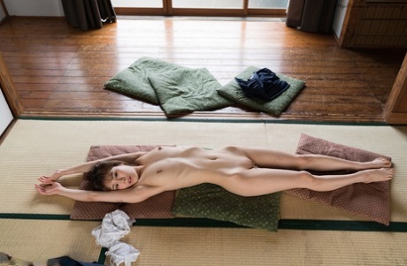 Young female Japanese athlete bares her thin legs on the cushion after school.