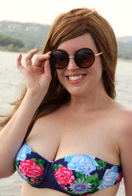 Chubby mature Holly Fuller flaunts her bikini to display herself with big cleavage and antlers on the back of a boat.
