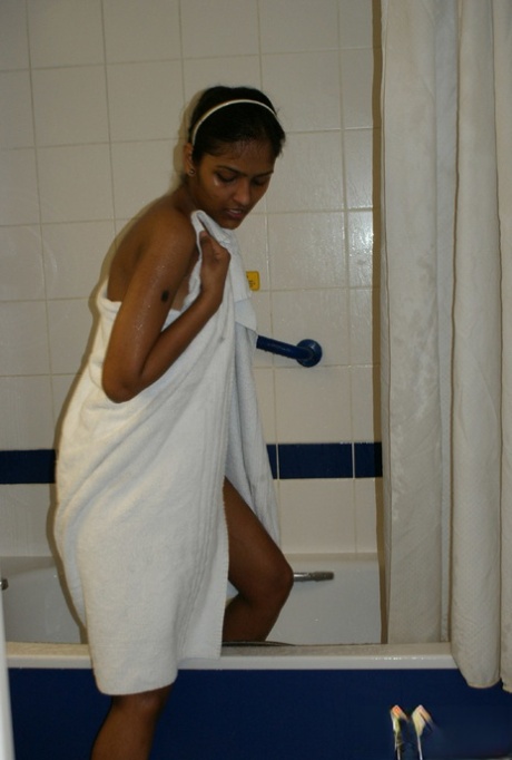 Desi, her first timer, takes a shower without clothes and then uses a towel to dry herself off.