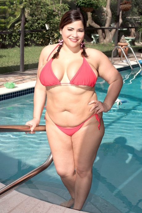 Fat girl removes her large natural tits from bikini top in pool.