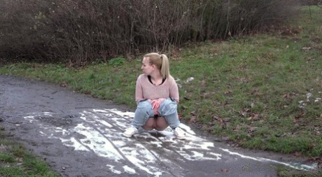 Clothed Girl Pulls Down Her Pants To Pee In A Muddy Puddle On A Path