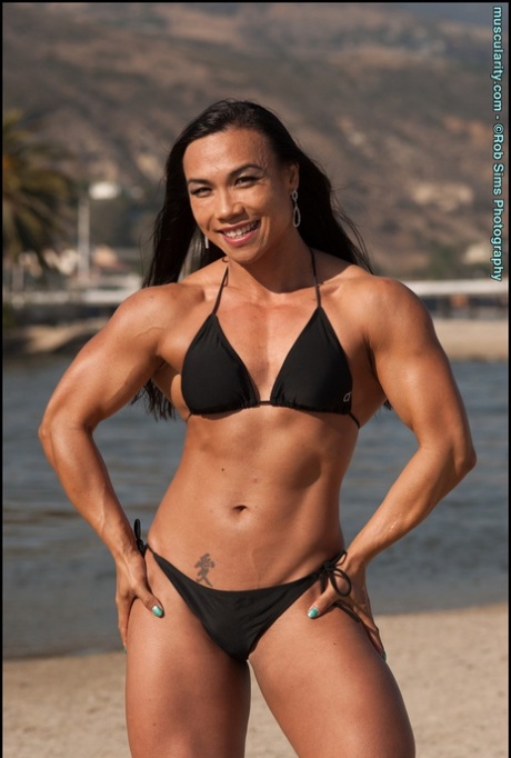 On a beach, Tram Nguyen an Asian bodybuilder shows off his new physique in a black bikini.