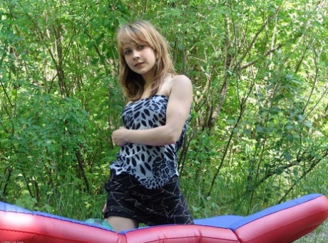 Teen first timer Liza strips naked on an air mattress surrounded by trees