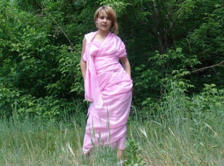 Teenage explorer Liza goes for first time: She is seen getting naked in the field, right in front of a tree line (far left).