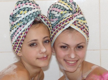 Teenage lesbians engage in non-nude bathroom activity by wearing matching bath towels.