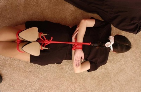 Brunette teen is hogtied in her clothing while sporting a cleave gag