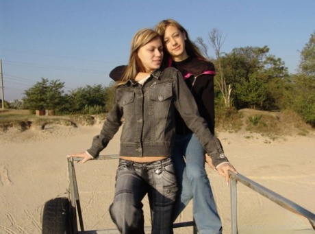 Young lesbians Lauraa and Katrina flaunt their tiny tits on the beach.