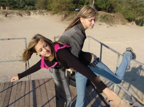 At the beach, young lesbians Lauraa and Katrina display their small tits.