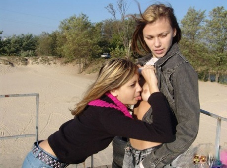 On the beach, Lauraa and Katrina, two young lesbians, display their tiny tits.