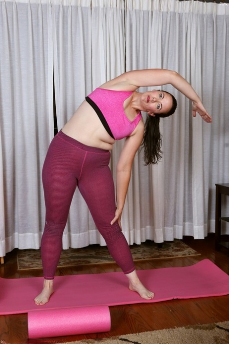A woman of middle age displays her hairy vagina during yoga sessions.
