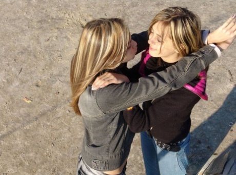 Katrina and Laura, both young lesbians, kiss outside and then start licking their bare chests.