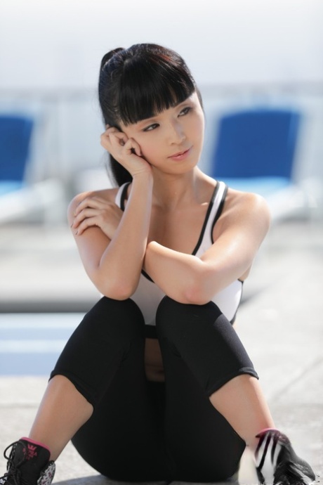 Cute Asian teen Marica Hase undressing outdoors to pose naked on her knees