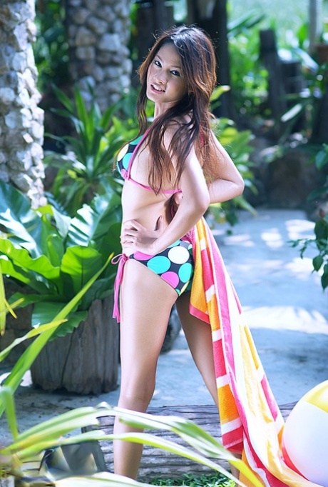 Taking off her bikini, Thai girl Ya Soraya is seen getting soaked in a garden.