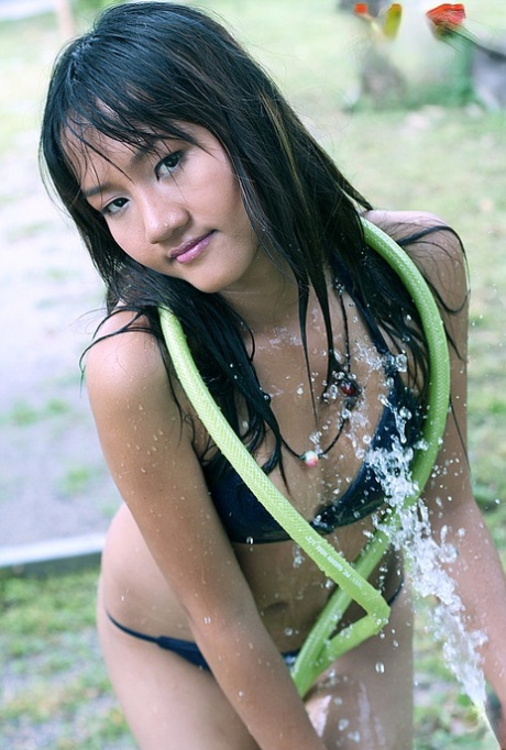 Худенькая тайка Эмбер Чан снимает мокрое бикини во дворе