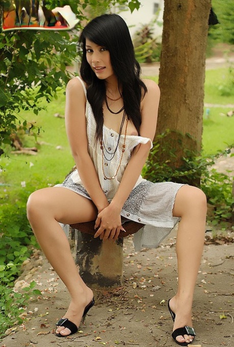 Jupjang Bunrugsa, a dark-haired Thai girl, exposes her attractive physique in a backyard setting.