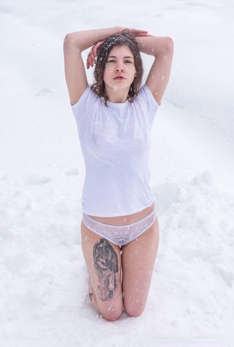A tattooed girl is compelled to kneel and stand without shoes in the snow.
