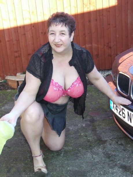 During car washing, Kinky Carol exposes her large tits while being washed.