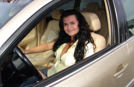 While driving, Busty Reny, a brunette amateur, displays her large belly.