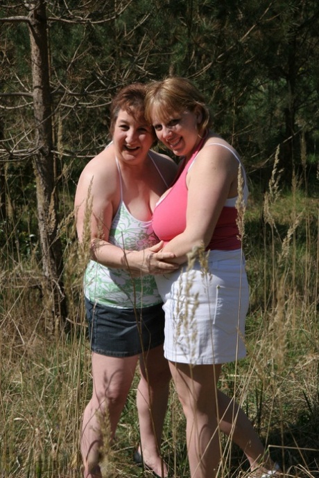 Big tits: Older lady Kinky Carol and her partner stand near the trees with their big tits sticking out of them.